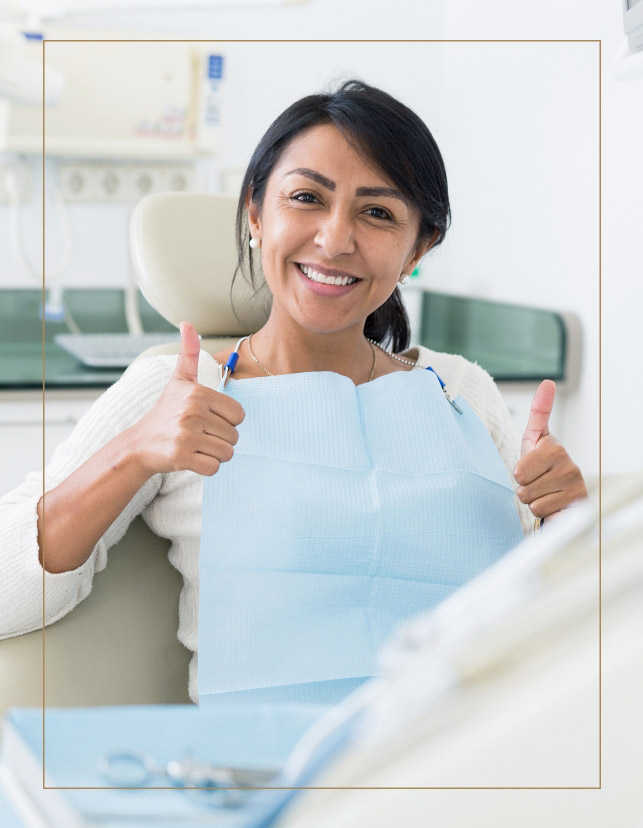 Satisfied patient wearing an apron and smiling with thumbs up