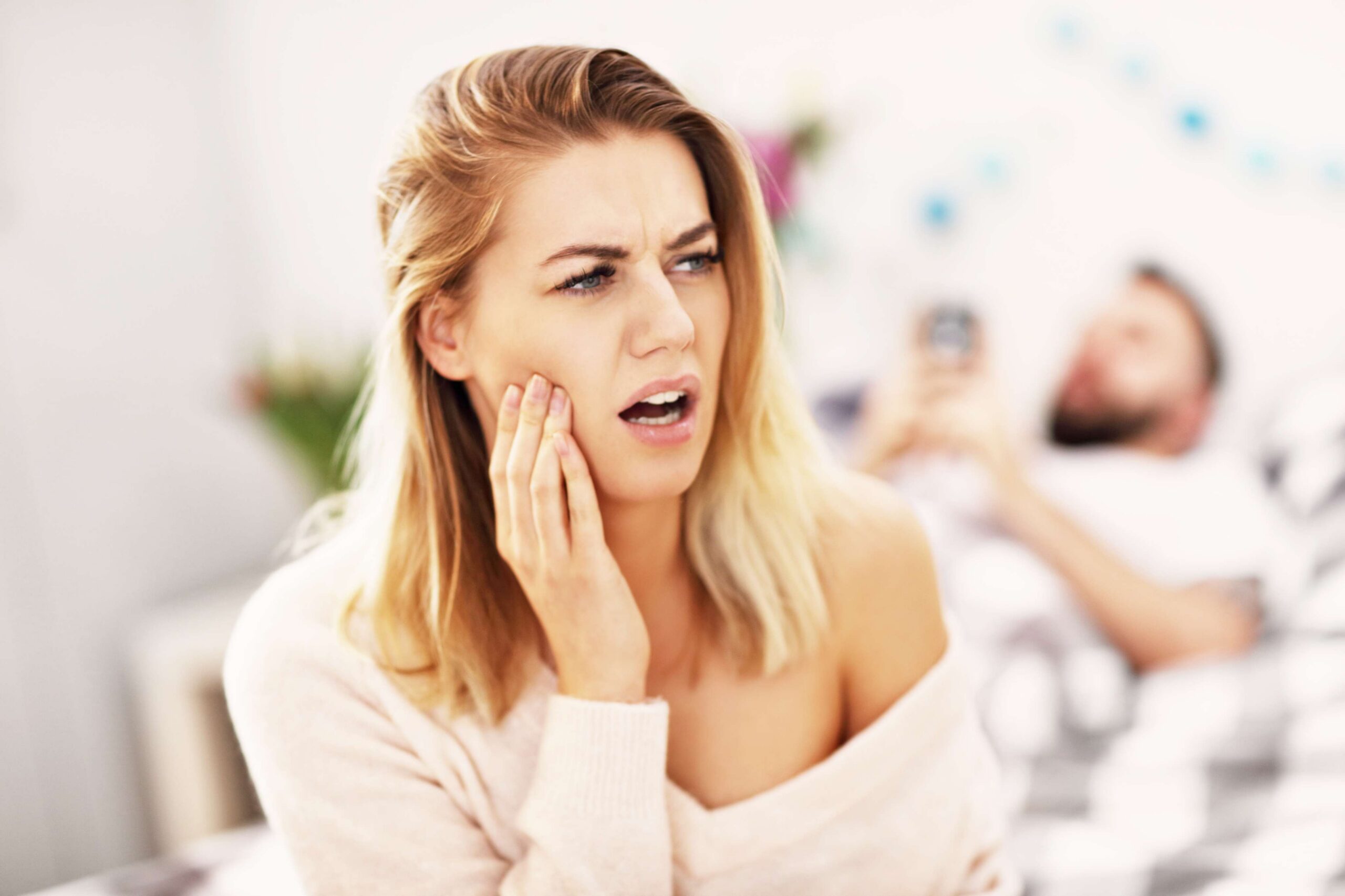 Woman holding her jaw with severe tooth pain.