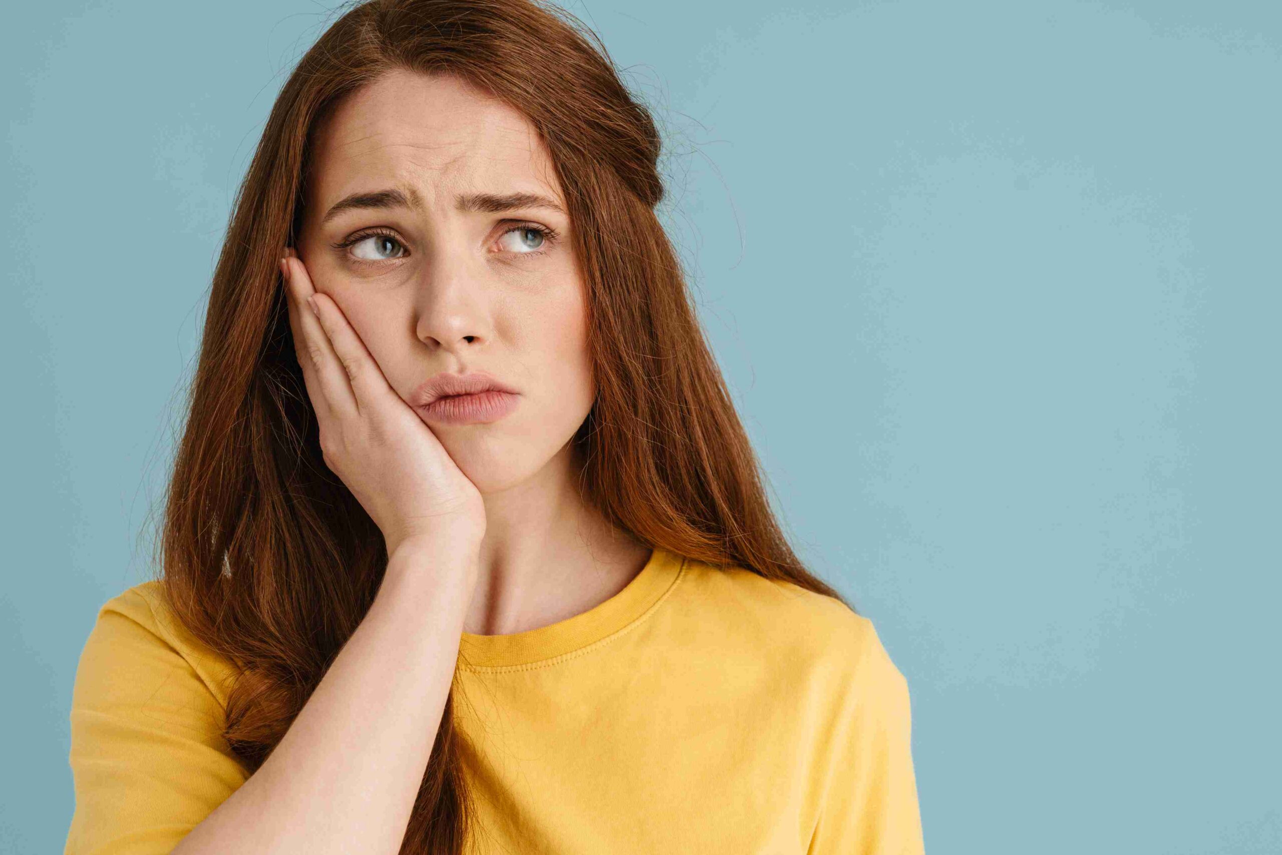 Woman holding her jaw with a painful toothache.